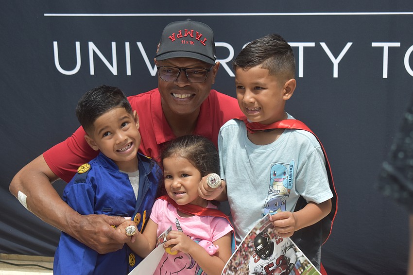 Shelton Quarles poses for a photo with Rowan, 4, Madison, 3, and Grayson Izaguirre, 6. If they were superheroes, Rowan would be the Hulk, Madison would be a unicorn and Grayson would be Spiderman.