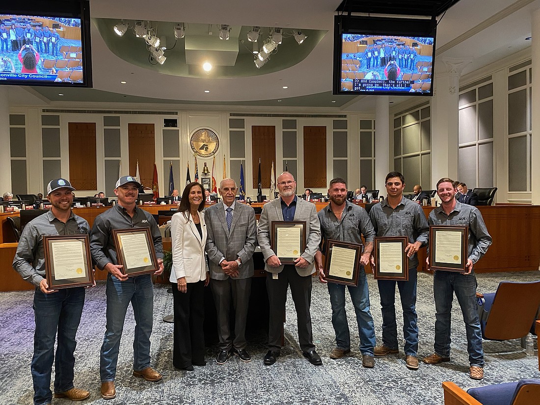 From left, JEA lineworkers Ryan Kornegay and Noah Sapp; JEA Managing Director and CEO Vickie Cavey; Council President Randy White; JEA Director, Electric Distribution, Construction, Maintenance Jerry Creel; lineworkers Cody Stokes, Caleb Macabitas and Hunter Thomas.