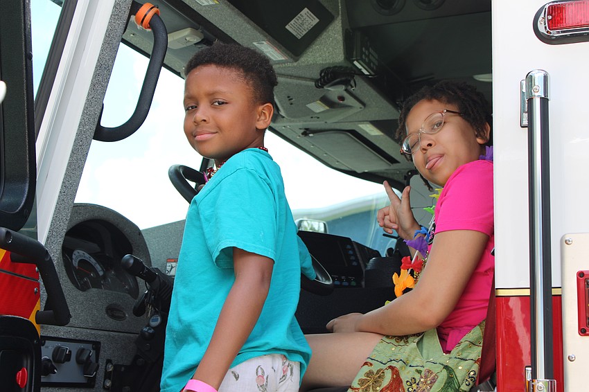 Harper and Dory Rogers say hello while touring the cab of a fire truck, one of the family-friendly activities at Diverse Fest.