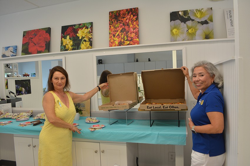 Irina LaRose c-owner of Design 2000 and Alzira Meierling member of the Rotary Club showing of the pizza from Venturas Italian Kitchen and Wine.