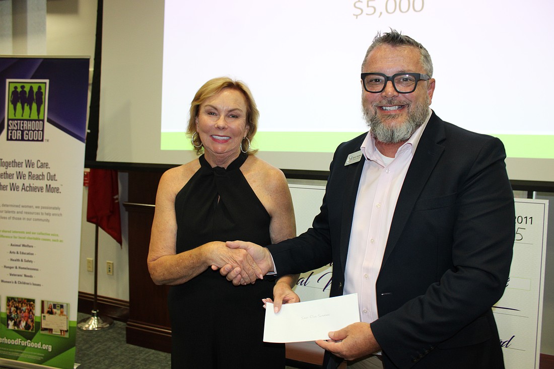 Sisterhood for Good's Pamela Modisett presents a grant check for $5,000 to Save Our Seabirds Executive Director Brian Walton June 19 at the Annual Grants Ceremony at Gold Coast Eagle Distributing in Lakewood Ranch.