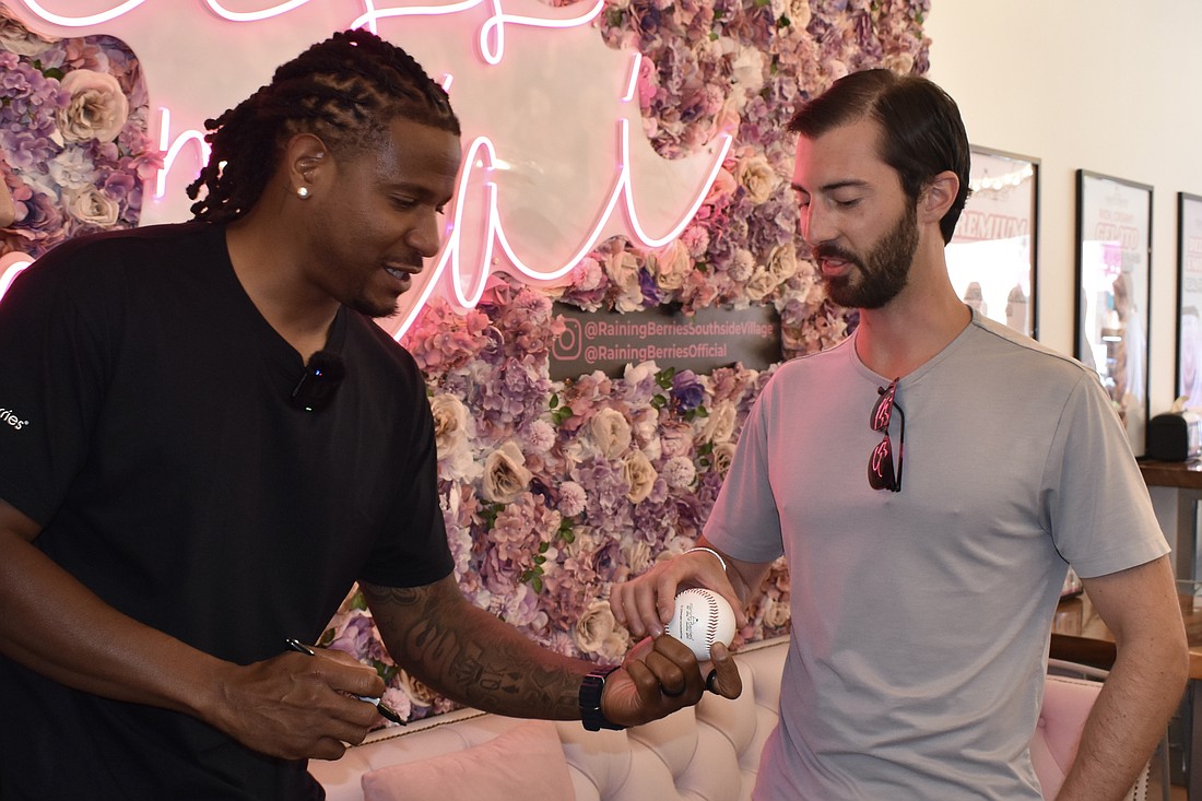 Edwin Jackson hands an autographed baseball to Luke Holcomb, a friend of Raining Berries Founder Bimal Bhojani.