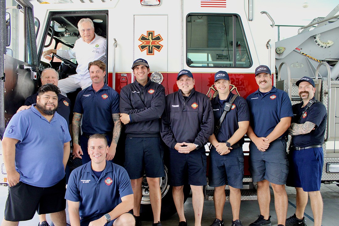 Chef José Martinez of Maison Blanche hops in the cab of a fire engine after he and Juan Gomez join the Rotary Club of Longboat Key in preparing a special thank-you lunch to members of Fire Station 2 with Longboat Key Fire Rescue.