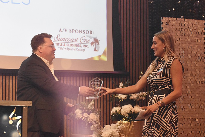 Daniel DeLeo at Shumaker, Loop & Kendrick, presents the Small Business of the Year award to Amanda Parrish, a partner and COO of Fawley Bryant Architecture.