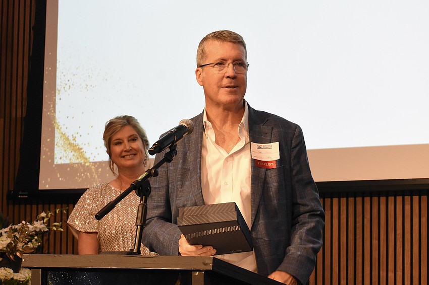Heather Kasten, president and CEO of the Greater Sarasota Chamber of Commerce, looks on as Stephen Heese of Chris-Craft claims the award for Workforce Development & Innovation.
