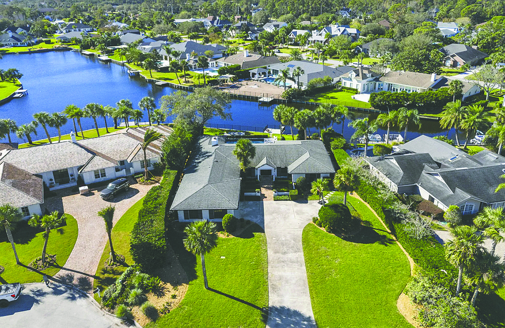 Lakefront single-story home features four bedrooms, three full and one half-bathrooms, office, pool and deck