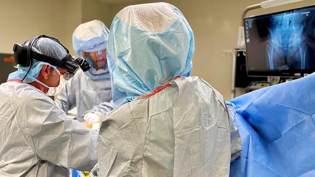 Orthopedic surgeon Dr. Edward Stolarski wears Microsoft HoloLens 2 mixed reality glasses to overlay 3D holograms of a patient's pelvis onto the hip during surgery. The enhanced visualization enables him to precisely plan and position custom implants to fit each patient’s unique anatomy.