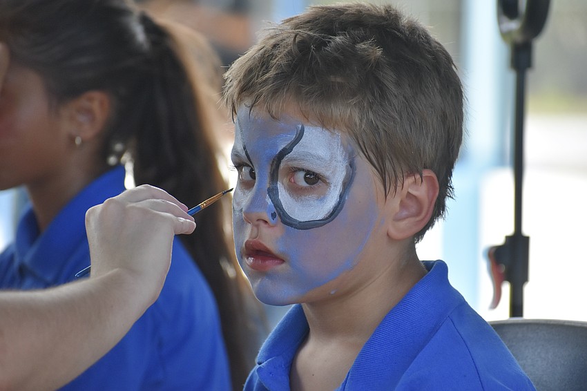 Logan Jackson, 8, has his face painted by Valeria Branciforte, a student at Ringling College of Art and Design.