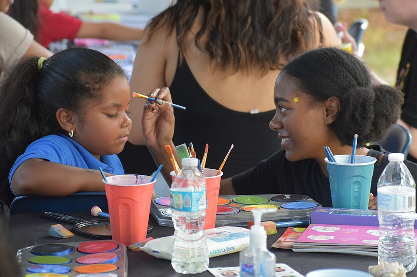 Luleydi del Rosario, 5, has her face paintedb by Jorja Henwood, a student at Ringling College of Art and Design.