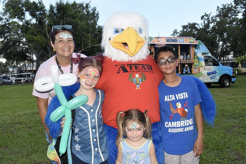 Teacher Heather Gomez, River Marshall, 8, her sister Millie Krystyniak, 3, and student Bryan Marchan, 11, meet Scout the Eagle.