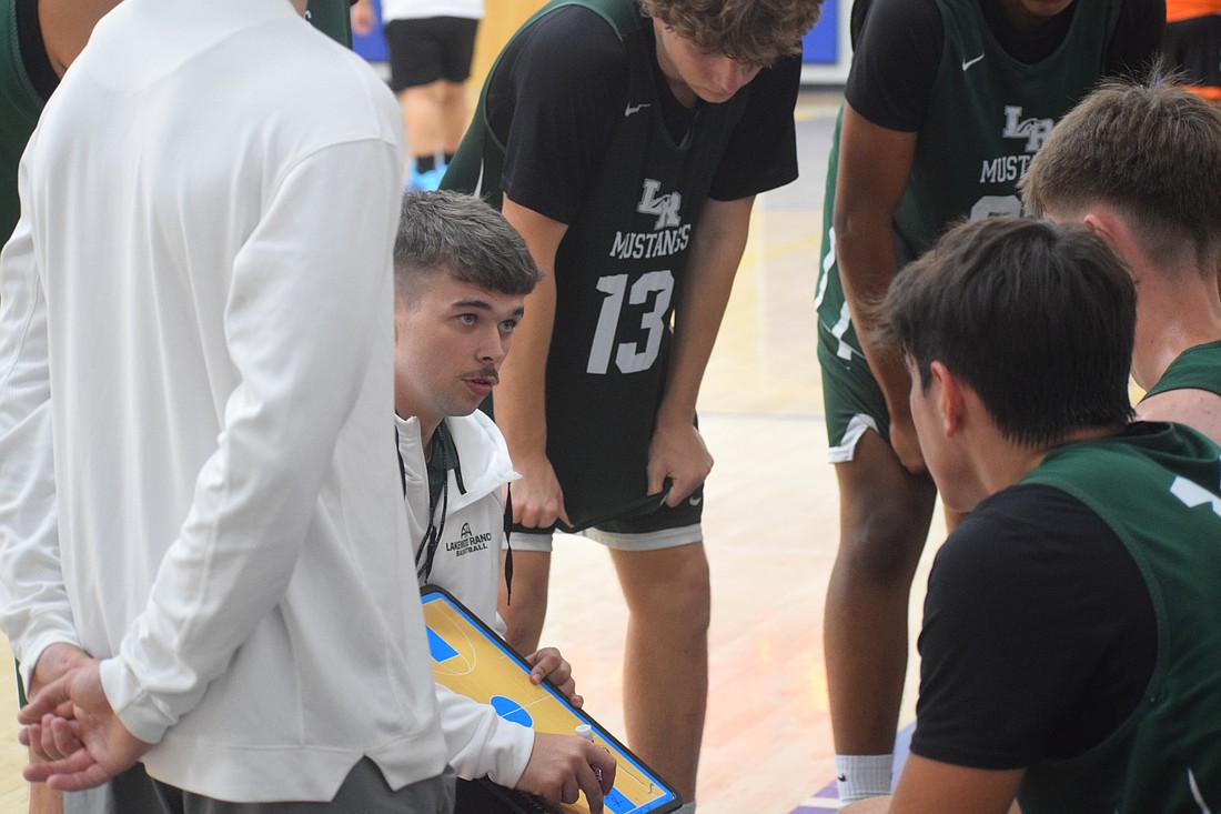 First-year Lakewood Ranch boys basketball coach Kaden Knott draws up a play during a timeout at a scrimmage at Imagine School of North Port on June 26.