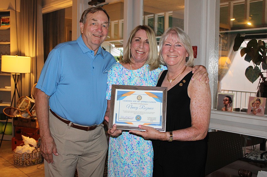 Jack and Nancy Rozance, joined by fellow Rotarian Carol Erker, accept commendation from the Rotary Club of Longboat Key for their years of service.