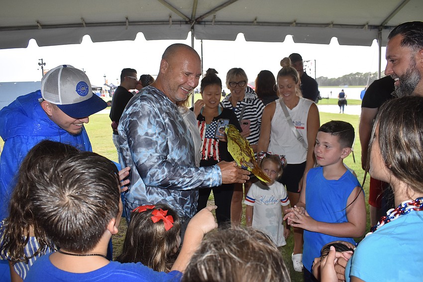 Lyle Pohlen's parrot Taco attracts a crowd under the tent as people get out of the rain during Fireworks on the Lake at Nathan Benderson Park.