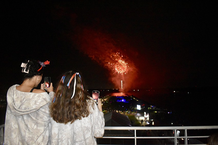 Best friends Olivia Geler and McKenna Bonura snap their photos from the finish tower July 3 at Nathan Benderson Park during Fireworks on the Lake.