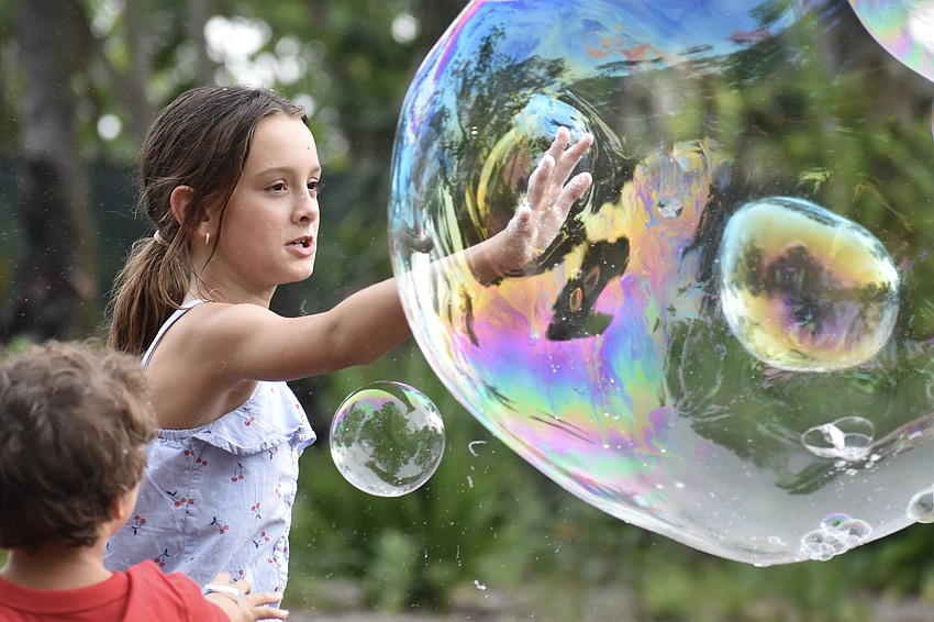 Natalia Eicher, 11, pops a bubble.