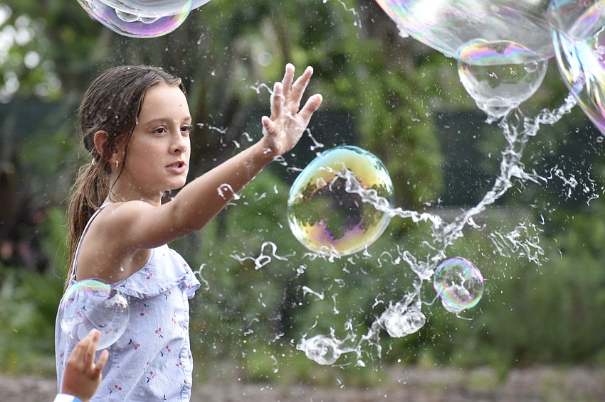 Natalia Eicher, 11, pops a bubble.