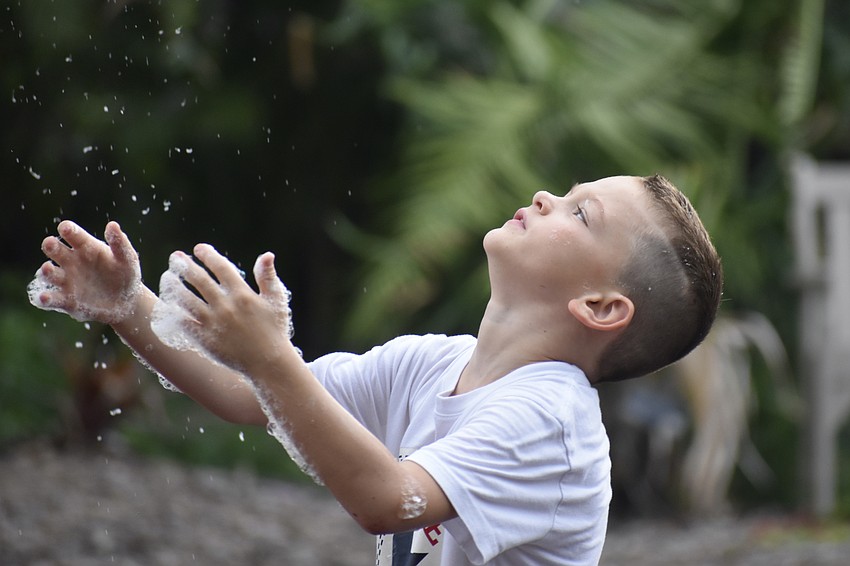 Charlie Eicher, 7, watches as a stream of bubbles approaches.