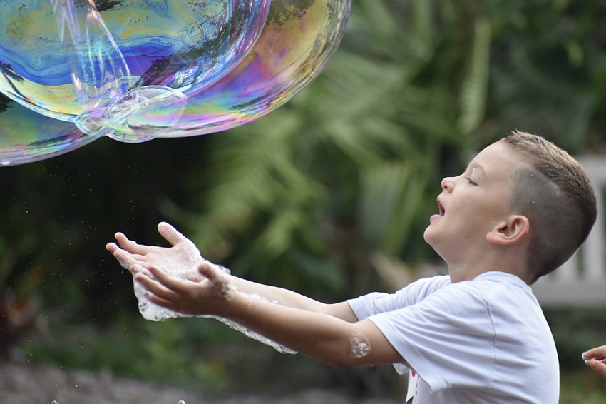 Charlie Eicher, 7, welcomes a stream of bubbles.