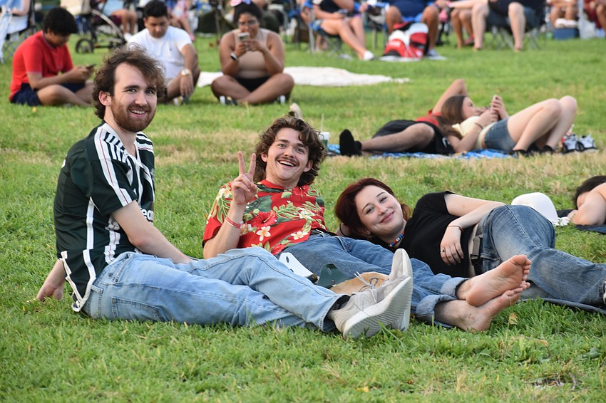 Liam Stokes, his brother Brian Stokes, and Brian's girlfriend Alicia Kamski enjoy the park grass.