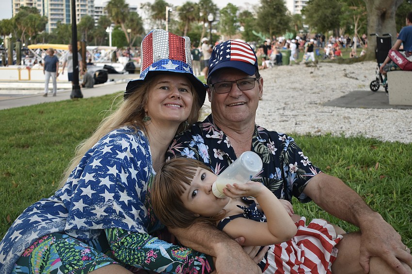 Irina Smirnova, her husband Luther Landrum and their daughter Olivia Landrum, 2, enjoy a spot in the grass.