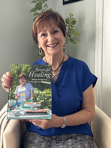 Patti Comeau-Simonson holds up her book, 'Recipes for Healing, Working Through Grief One Plate at a Time. (Just Not Lasagna!)' Courtesy photo
