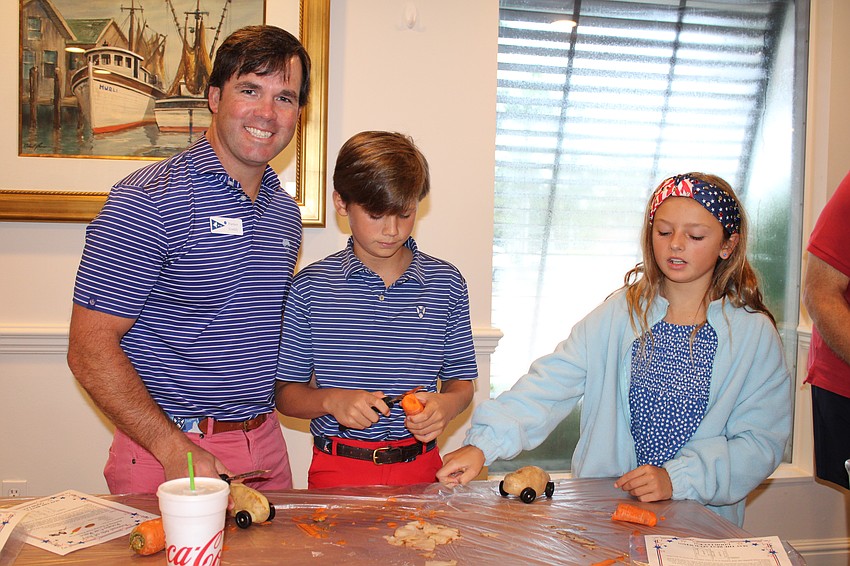 Parker Gaddy, Marabella Hensen and McLean Gaddy prep their potato race car for the Fourth of July race at Bird Key Yacht Club.