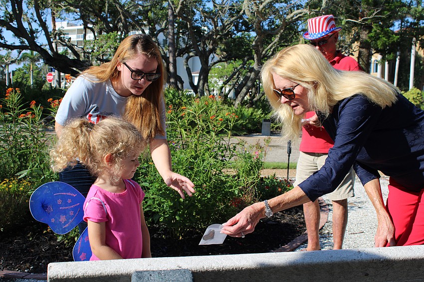 This year's Freedom Fest grand marshal Susan Phillips hands out butterflies for the release at the park on July 5.