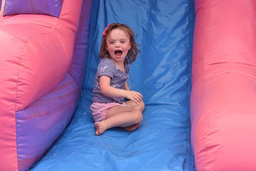 Lakewood Ranch resident Hannah Bellan, 2, is happy to go down an inflatable slide for the first time.