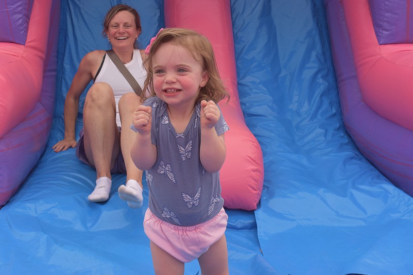 Lakewood Ranch resident Nicole Bellan and her daughter Hannah Bellan, 2, go down the inflatable slide together at Movie in the Park.