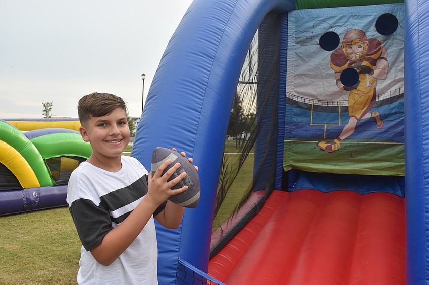 Sarasota resident Daniel Duvanov, 14, finds a spot to satisfy his love of sports at Movie at the Park July 11.