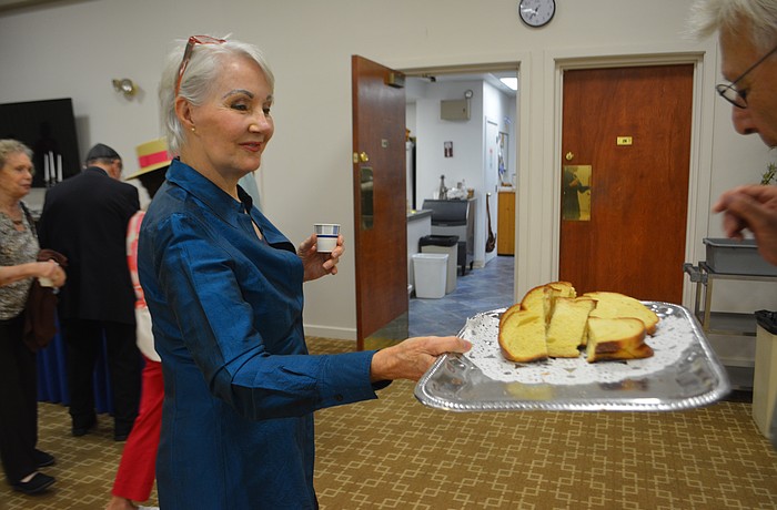 Cantorial sololist Kei Sulhi hands out challah to start the celebration of the Shabbat.