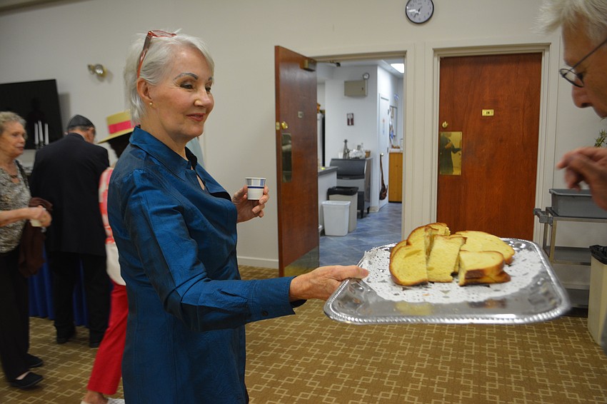 Cantorial sololist Kei Sulhi hands out challah to start the celebration of the Shabbat.