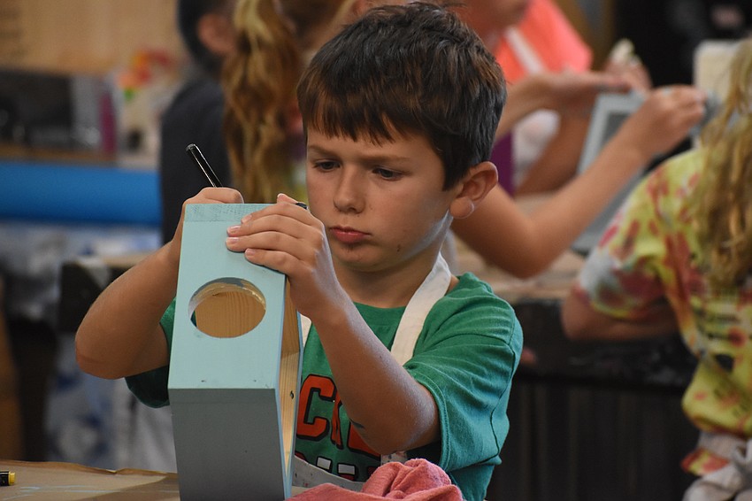 Brendon Letarte, 8, writers on his project with a marker.