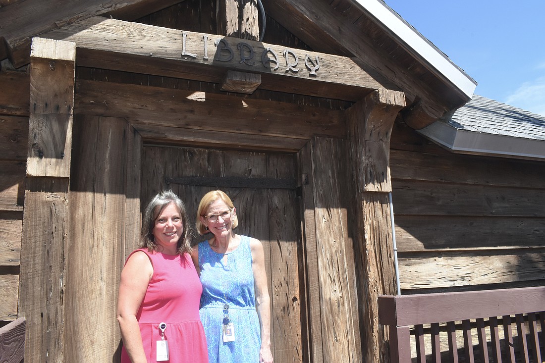 Jessica Bank and Laura Murphy stand in front of the library.