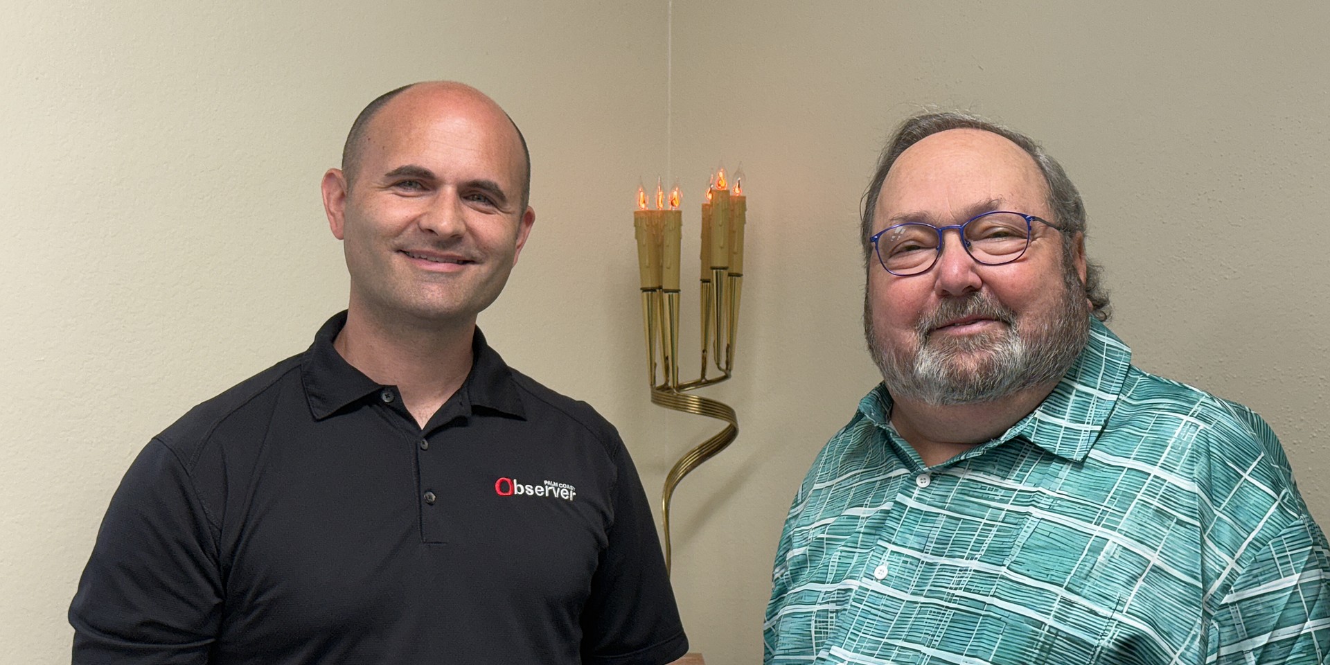 Observer Publisher Brian McMillan, with Jewish Federation Rabbi Dr. Robert Lennick, at the construction trailer at 470 Andalusia Ave., Ormond Beach. In the corner, you can see the the Yad Vashem Memorial Light, "commemorating the 6 million Jewish martyrs" from the Holocaust. It was presented by Stuart Jeff Doliner, in honor of his bar mitzvah in 1970. Photo by Elizabeth McMillan
