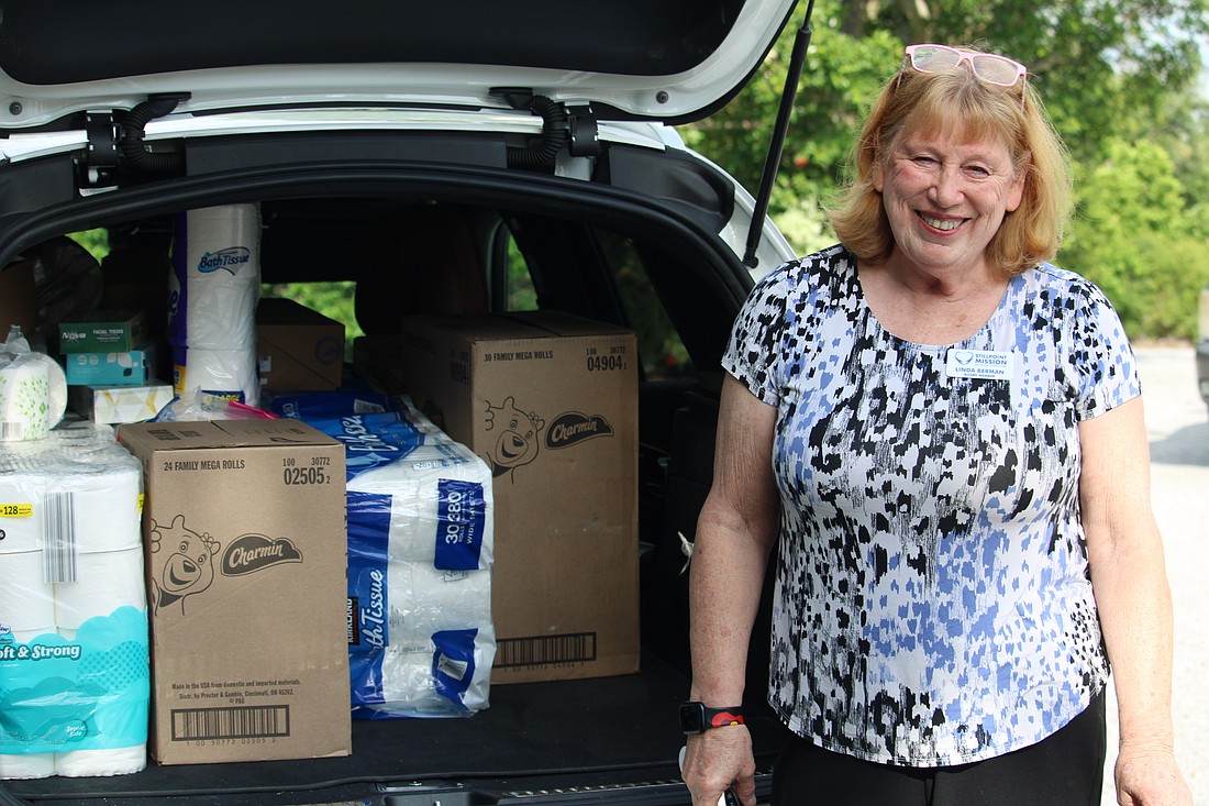Linda Berman, board member at Stillpoint Mission, fills her car with donated toilet paper from members of Longboat Island Chapel on July 15.