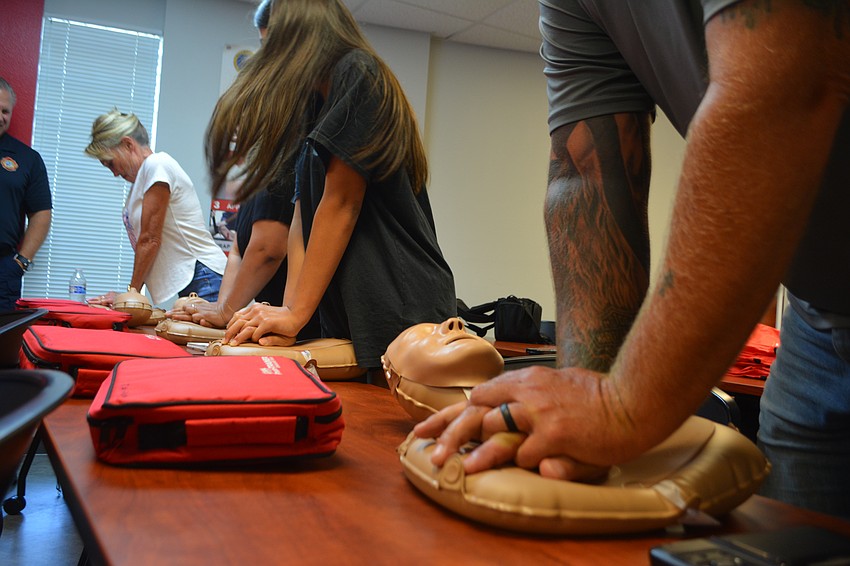 Class participants work hard to get 120 compressions per minute on the CPR mannequins.