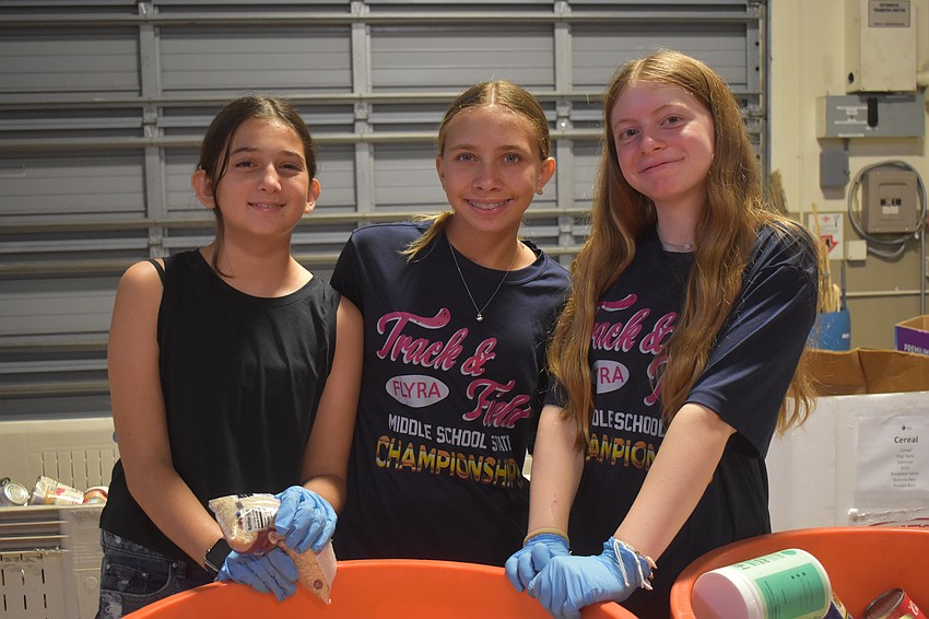 Lakewood Ranch's Sophie Patel, 12, Bradenton's Sophia Antipov, 12 and Lakewood Ranch's Kylie Caserta, 12, use teamwork to work through the bin of food together.