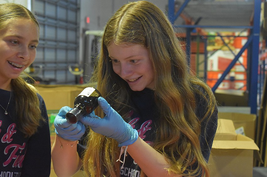 Bradenton's Sophia Antipov, 12 and Lakewood Ranch's Kylie Caserta, 12, search for an expiration date while simultaneously laughing and talking.