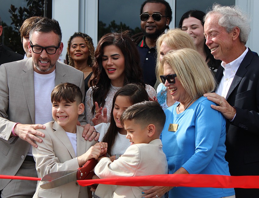 City Furniture CEO Andrew Koenig (left), and his dad, Keith Koenig (right), who is the company founder, gathered their family for the ribbon cutting July 17 at UTC.