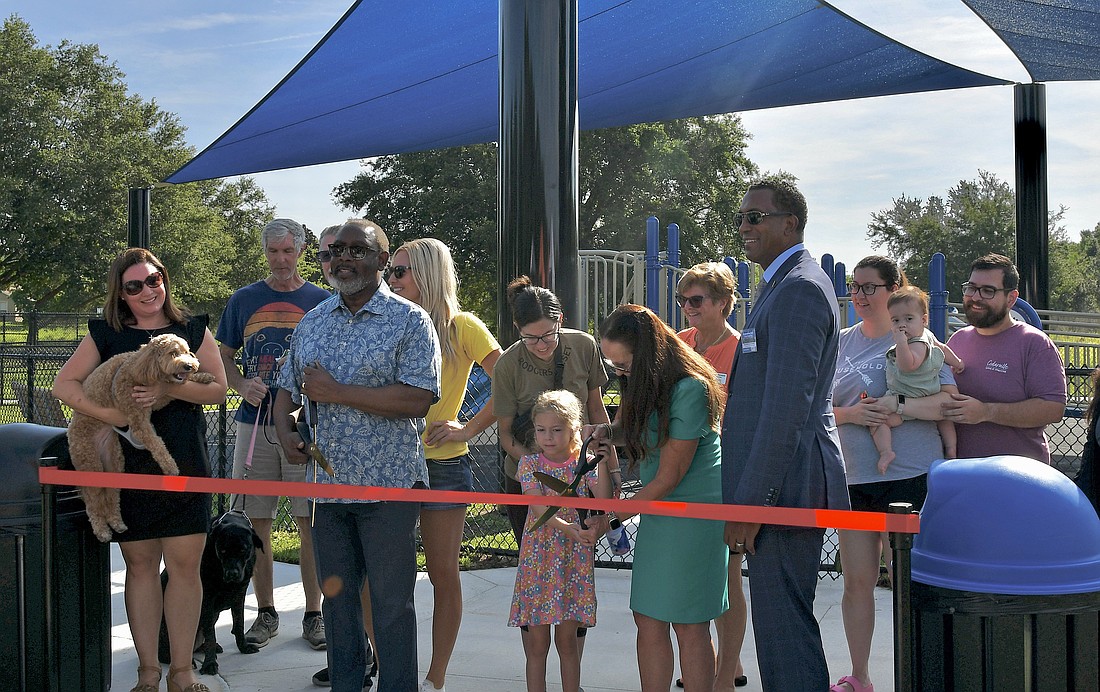 Orange County Major Jerry Demings and District 1 Commissioner Nicole Wilson held scissors to open Bentonshire Park. Community members stood with them in support of their new space.