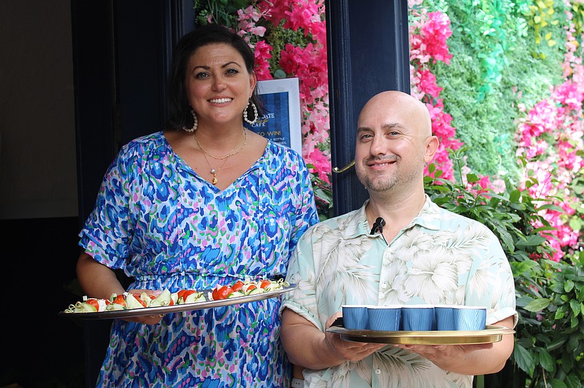 Eleni Sokos and Jared Fairley hand out beverages and small bites as part of 