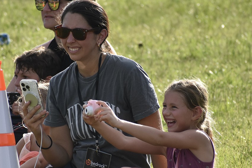Rebecca High and her daughter Kate High, 6, watch the show, while Kate takes a picture.
