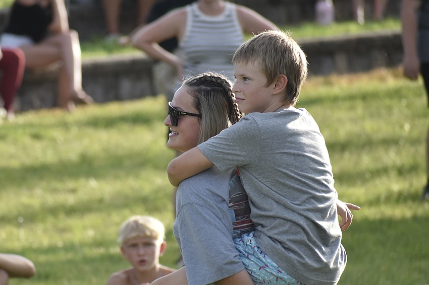 Abigail Hetzer, 14, carries her brother Abel Hetzer during a game that involves siblings picking one another up on command.
