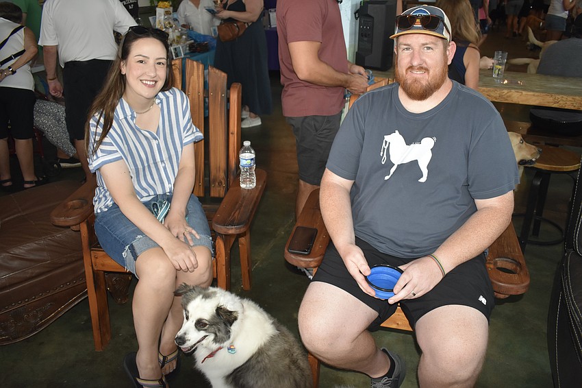 Carolyn Michael, her dog Milo, and her husband Taylor Regan sit in the lounge.