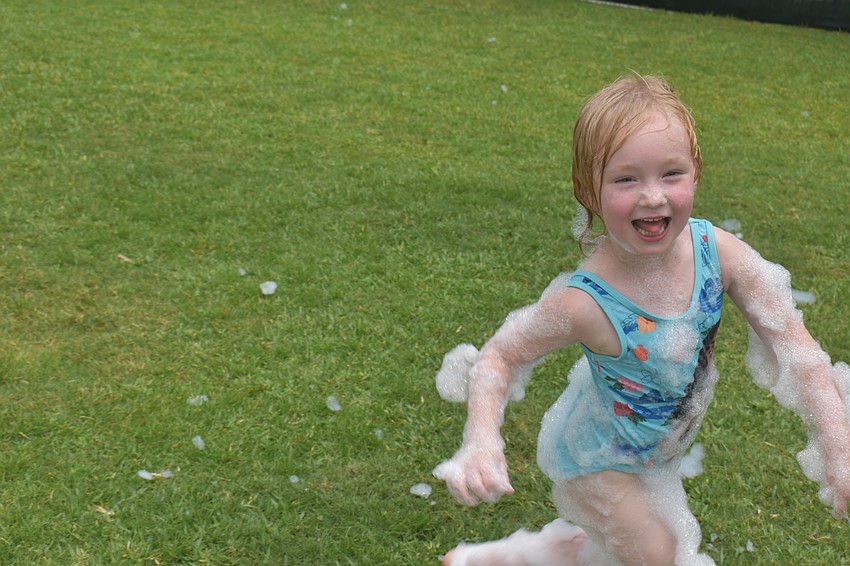 Wimauma resident Anastasia Oustimov, 5, comes out of the foam but takes a good bit of it with her.