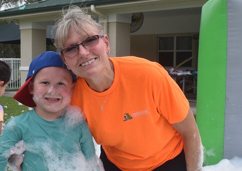 Sarasota resident Alijah Dixon, 5, still is covered with foam as he gets a hug from his grandma Cyndi Dixon, who has worked for Creative Child Learning Center for 25 years.