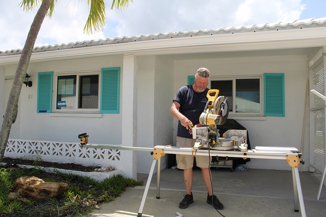 Pat Evans, an independent contractor, works on interior trim on a house in Spanish Main Yacht Club.