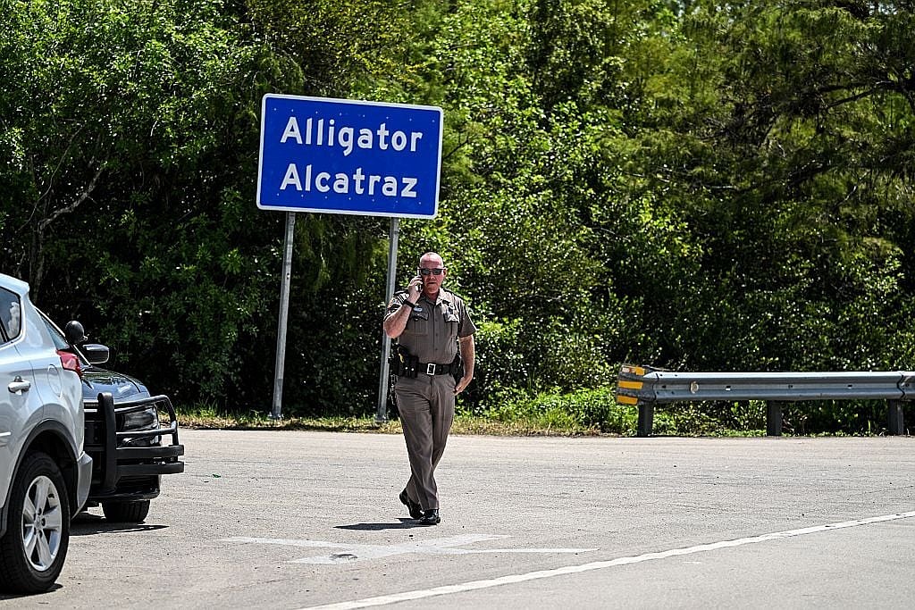 A Florida Highway Patrol officer looks on as protesters gather to demand the closure of the immigrant detention center known as "Alligator Alcatraz" at the Dade-Collier Training and Transition Airport in Ochopee, Florida, on July 22. Photo by Chandan Khanna/AFP via Getty Images