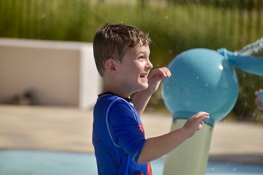 Grayson Triggs, 6, is waiting for the bucket to dump water on him.